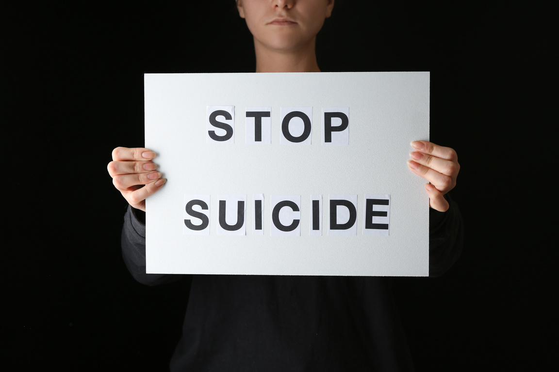 Person Holding a Stop Suicide Signage 